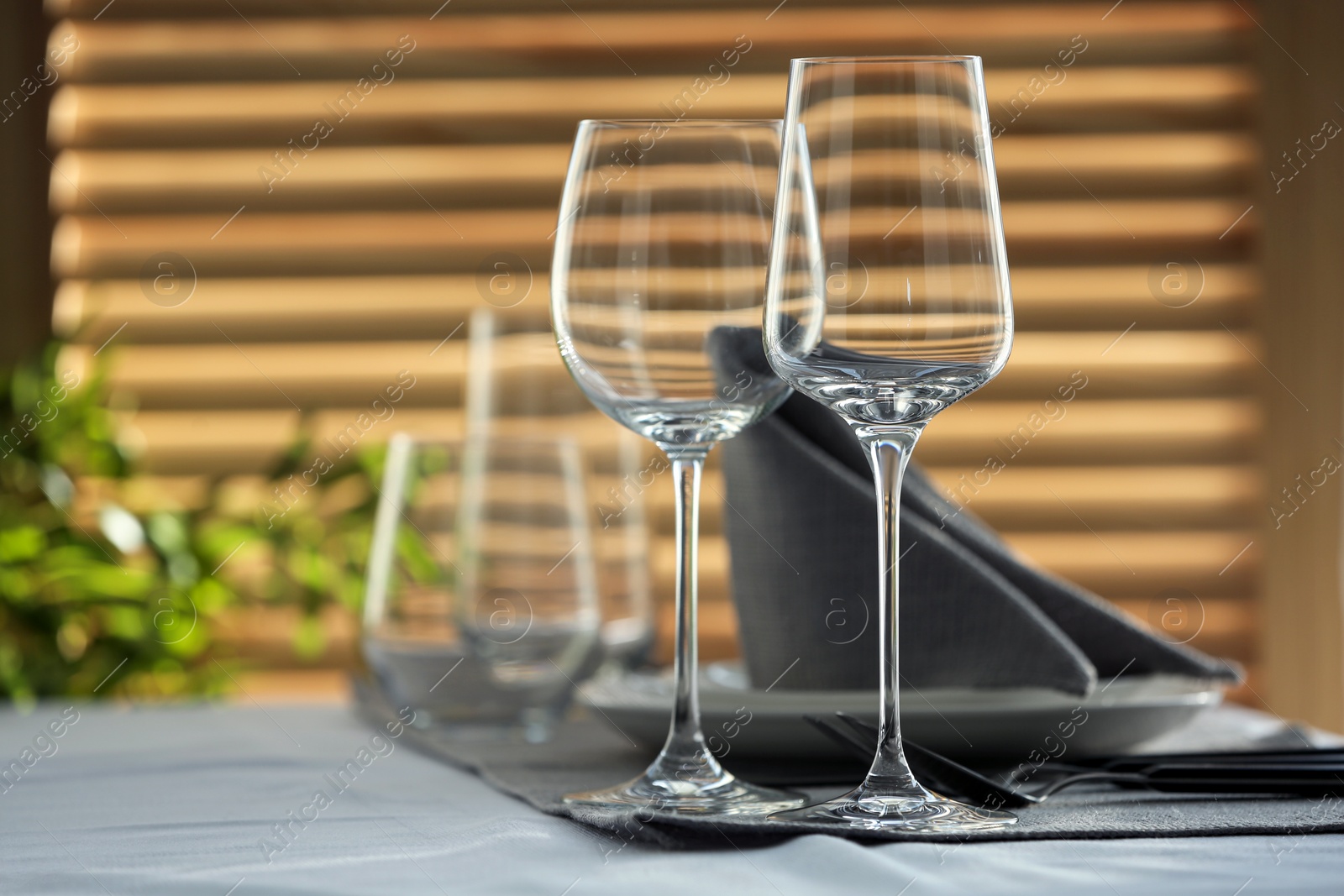 Photo of Table setting with empty wine glasses and napkin