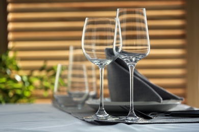 Photo of Table setting with empty wine glasses and napkin