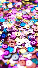 Many different colorful sequins as background, closeup