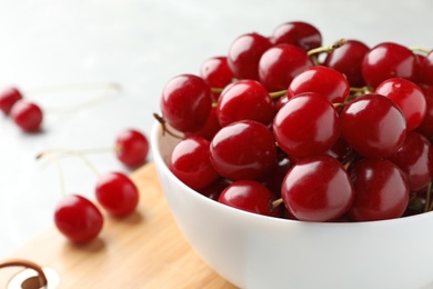 Bowl of tasty ripe cherries on board, closeup