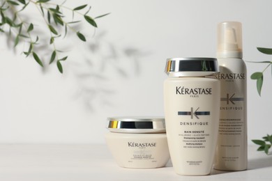 Photo of MYKOLAIV, UKRAINE - SEPTEMBER 07, 2021: Set of Kerastase hair care cosmetic products on white wooden table. Space for text