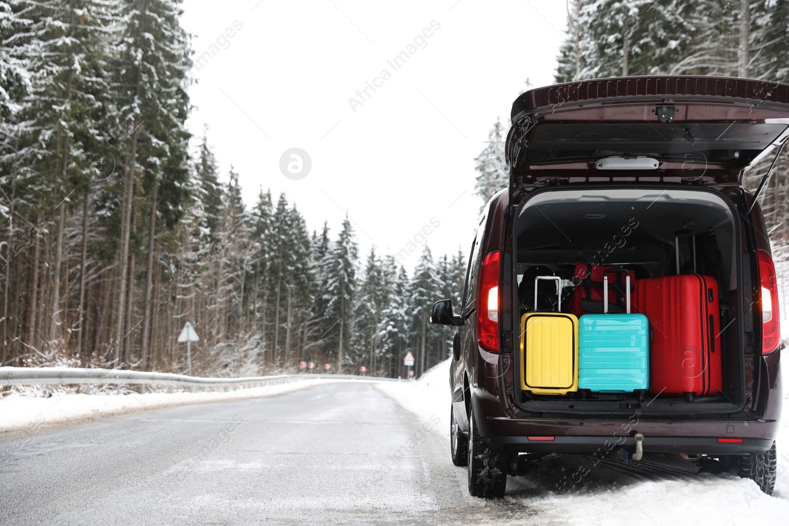 Photo of Car with open trunk full of luggage near road, space for text. Winter vacation