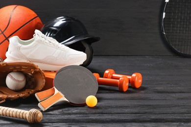 Photo of Many different sports equipment on dark grey wooden table