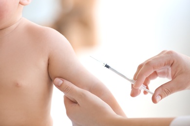 Photo of Doctor vaccinating baby in clinic, closeup