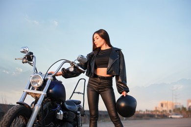 Photo of Beautiful young woman with helmet near motorcycle outdoors