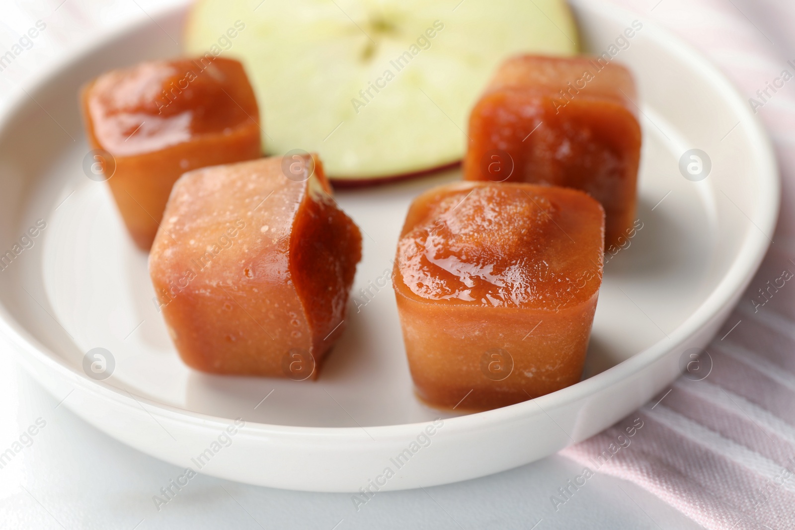 Photo of Frozen apple puree cubes with ingredient on table, closeup