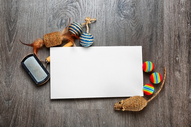 Photo of Composition with blank sheet of paper and cat's accessories on wooden background