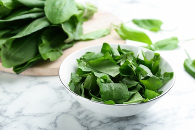 Photo of Fresh green sorrel leaves on white marble table, closeup