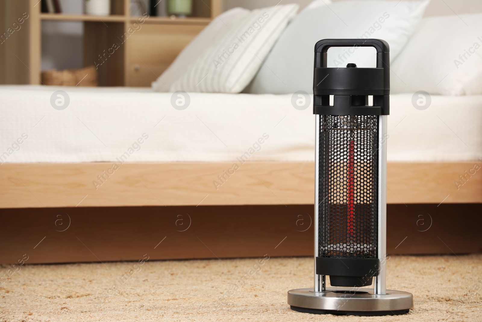 Photo of Modern infrared heater on carpet in cozy room. Space for text