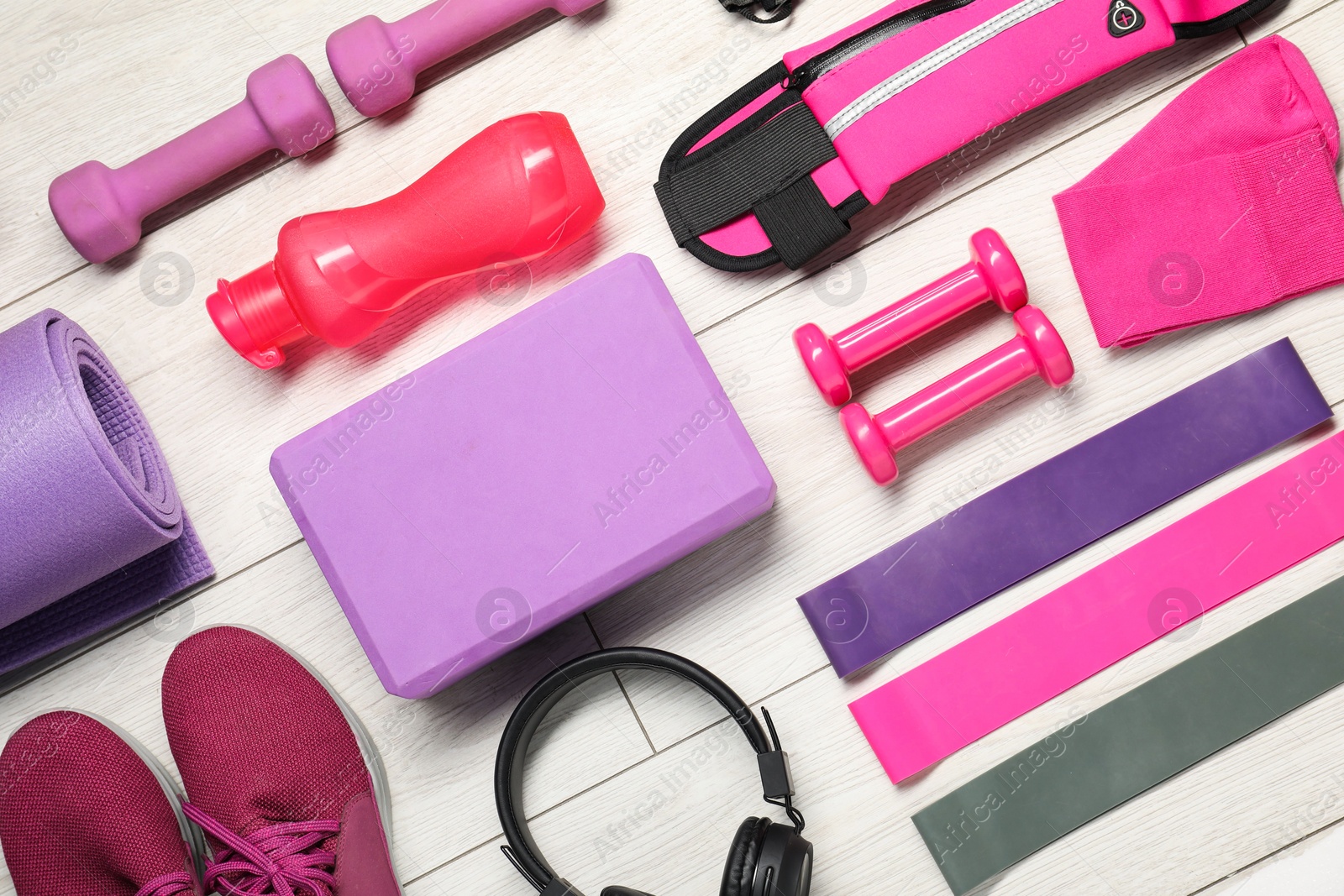 Photo of Different sports equipment on white wooden table, flat lay