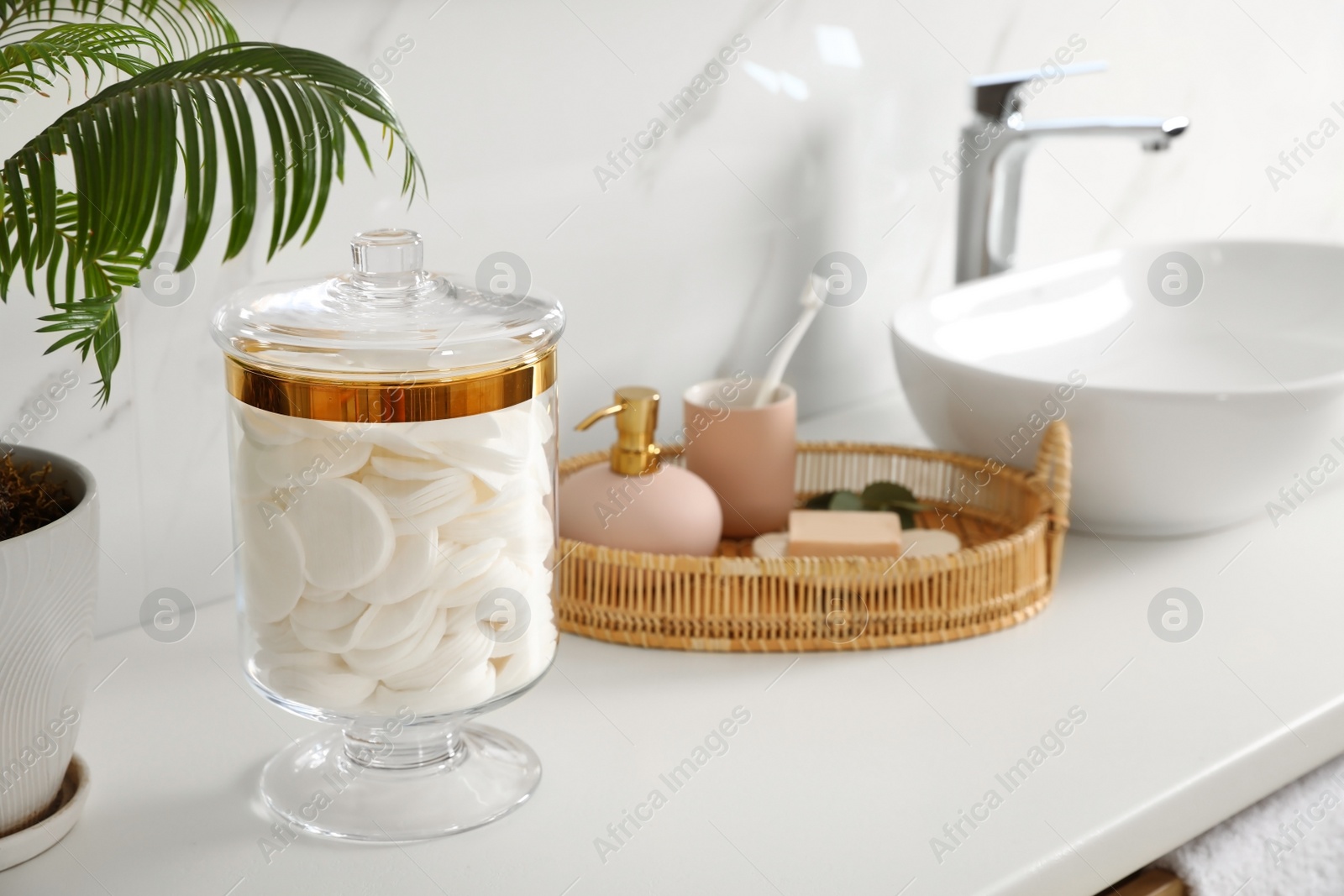 Photo of Jar with cotton pads on bathroom countertop