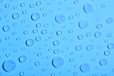 Photo of Water drops on color background, top view