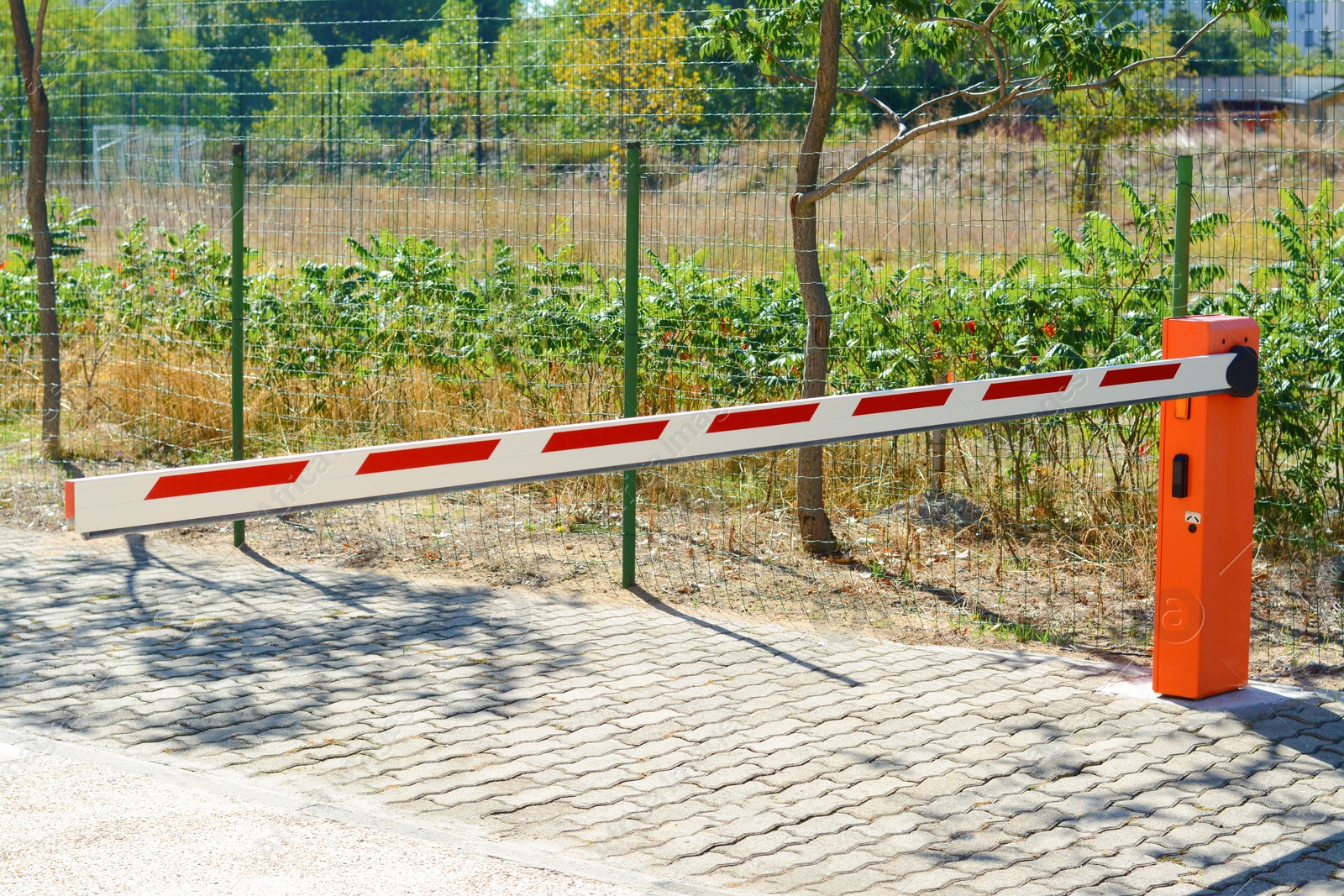 Photo of Closed boom barrier on sunny day outdoors