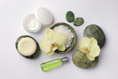 Photo of Flat lay composition with stones, spa products and beautiful flowers on white table