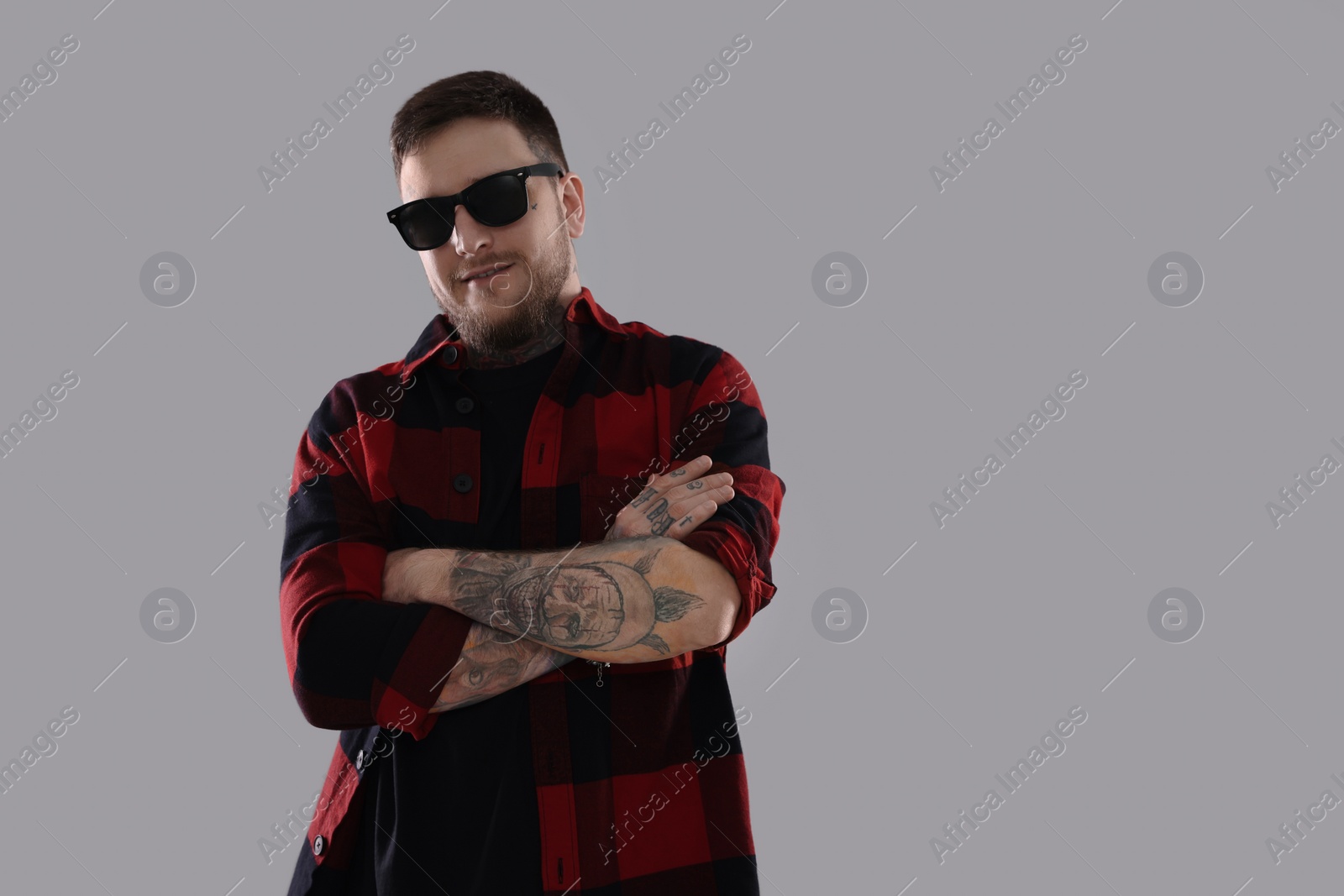 Photo of Handsome hipster man wearing stylish sunglasses on light grey background. Space for text