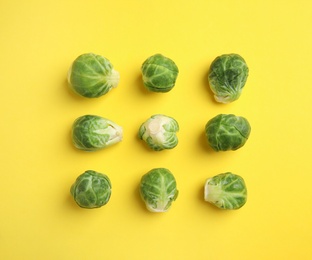 Fresh Brussels sprouts on yellow background, flat lay