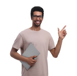 Smiling man with laptop pointing at something on white background