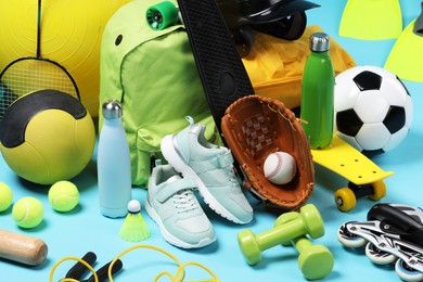 Many different sports equipment on light blue background, closeup