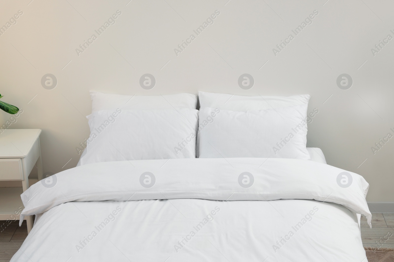 Photo of White soft pillows on cozy bed in room