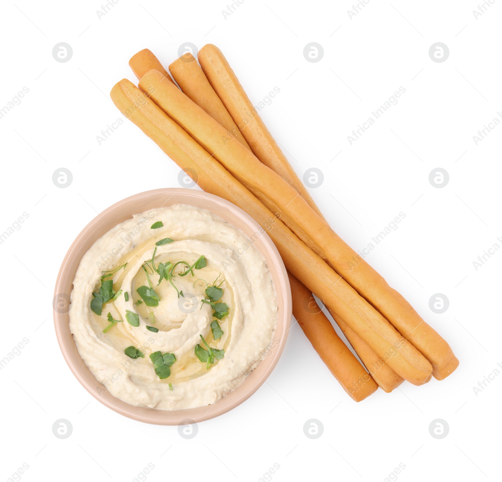 Photo of Delicious grissini sticks and hummus isolated on white, top view