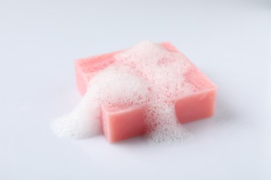 Soap with fluffy foam on white background