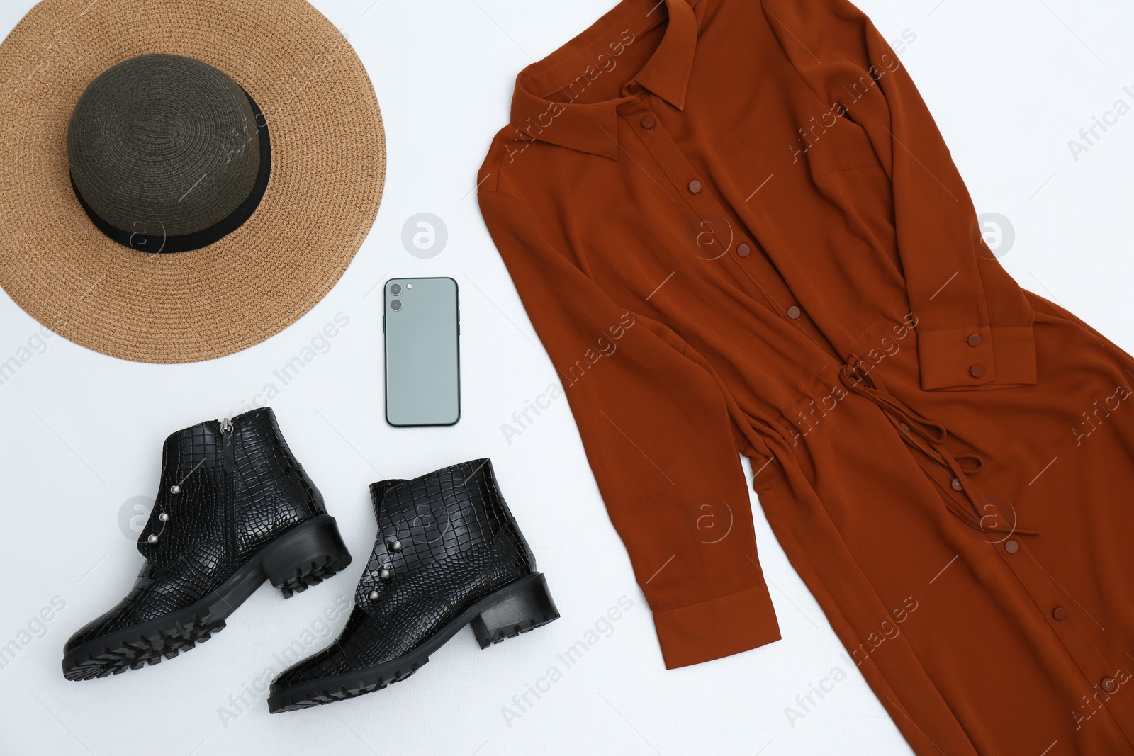 Photo of Set with ankle boots, stylish dress and mobile phone on white background, top view