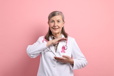 Photo of Mammologist with pink ribbon on color background. Breast cancer awareness