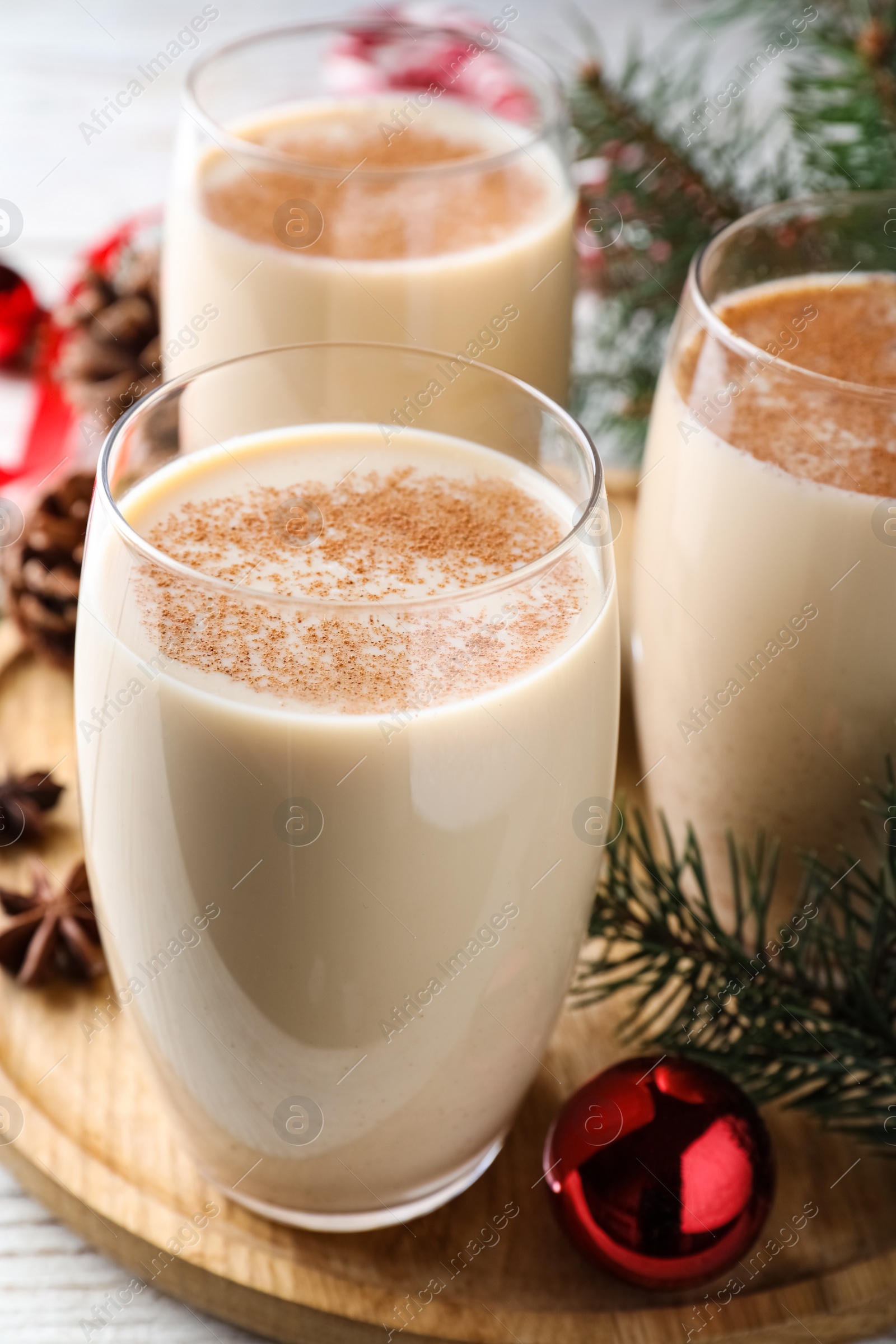 Photo of Delicious Christmas cocktail with liqueur on wooden board, closeup