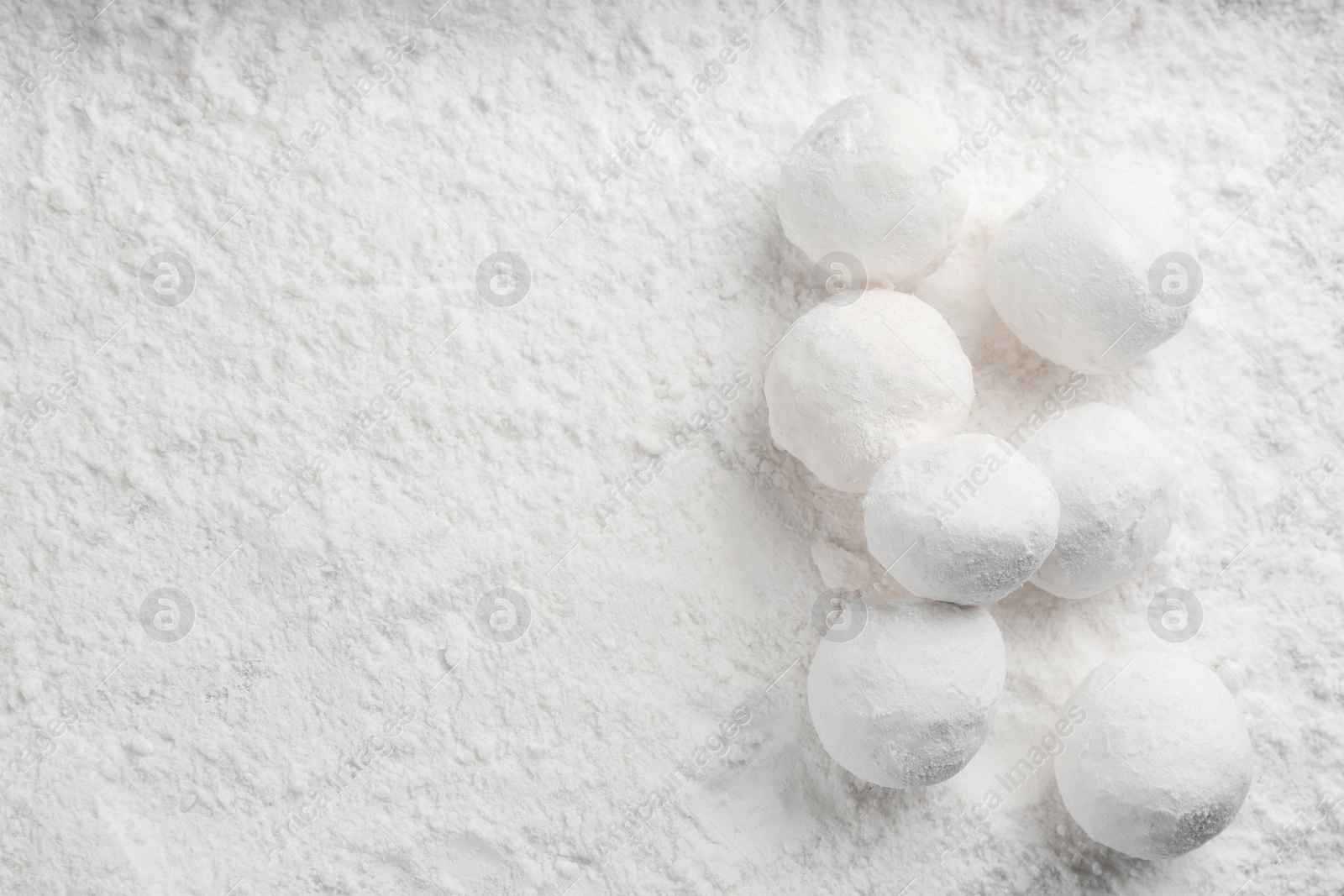 Photo of Round snowballs on snow, flat lay. Space for text