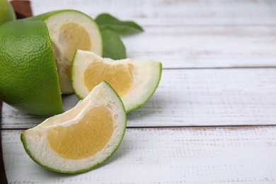 Cut fresh ripe sweetie fruit on white wooden table, closeup. Space for text