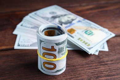 Many dollar banknotes on wooden table, closeup