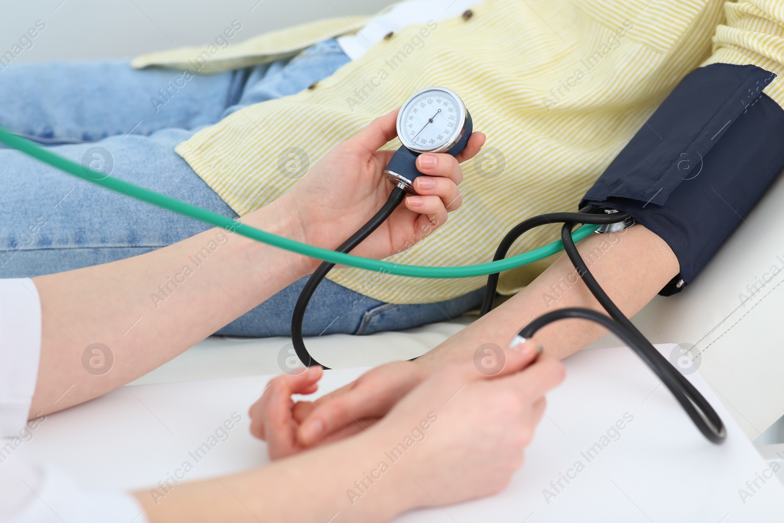 Photo of Doctor checking blood pressure of woman in clinic, closeup