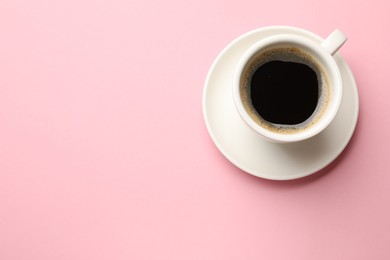 Fresh coffee in cup on pink background, top view. Space for text