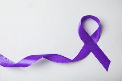 Purple ribbon on grey background, top view. Domestic violence awareness