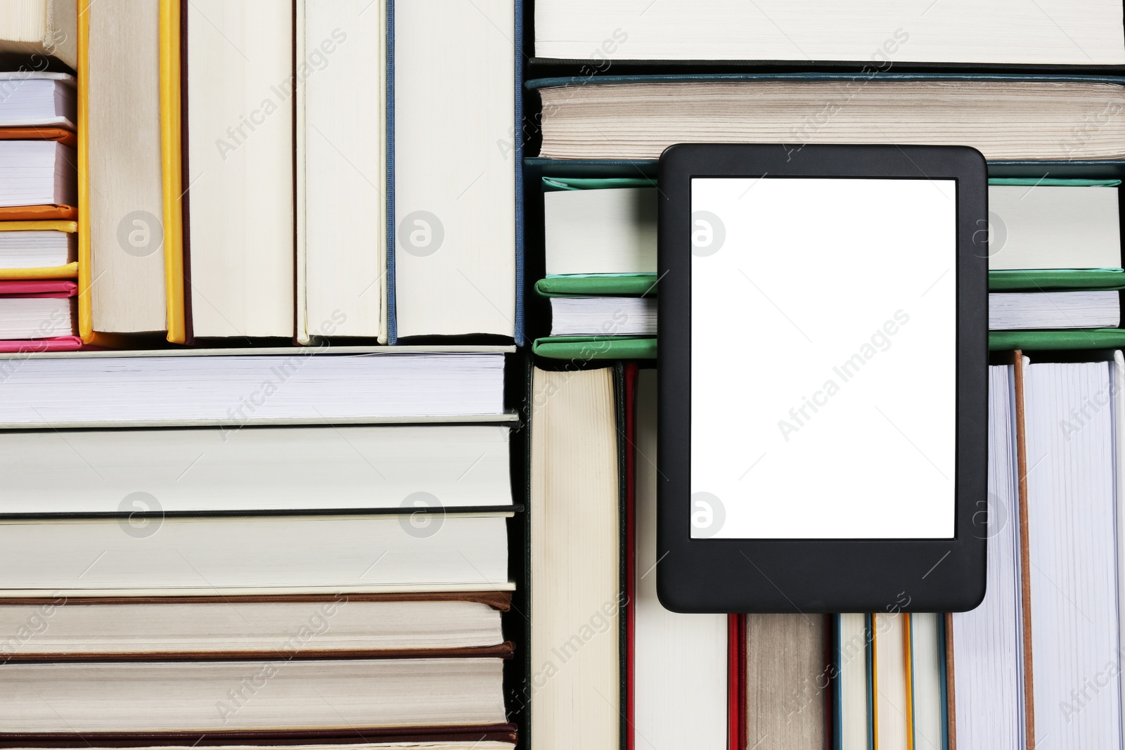 Photo of Portable e-book reader on different hardcover books, top view