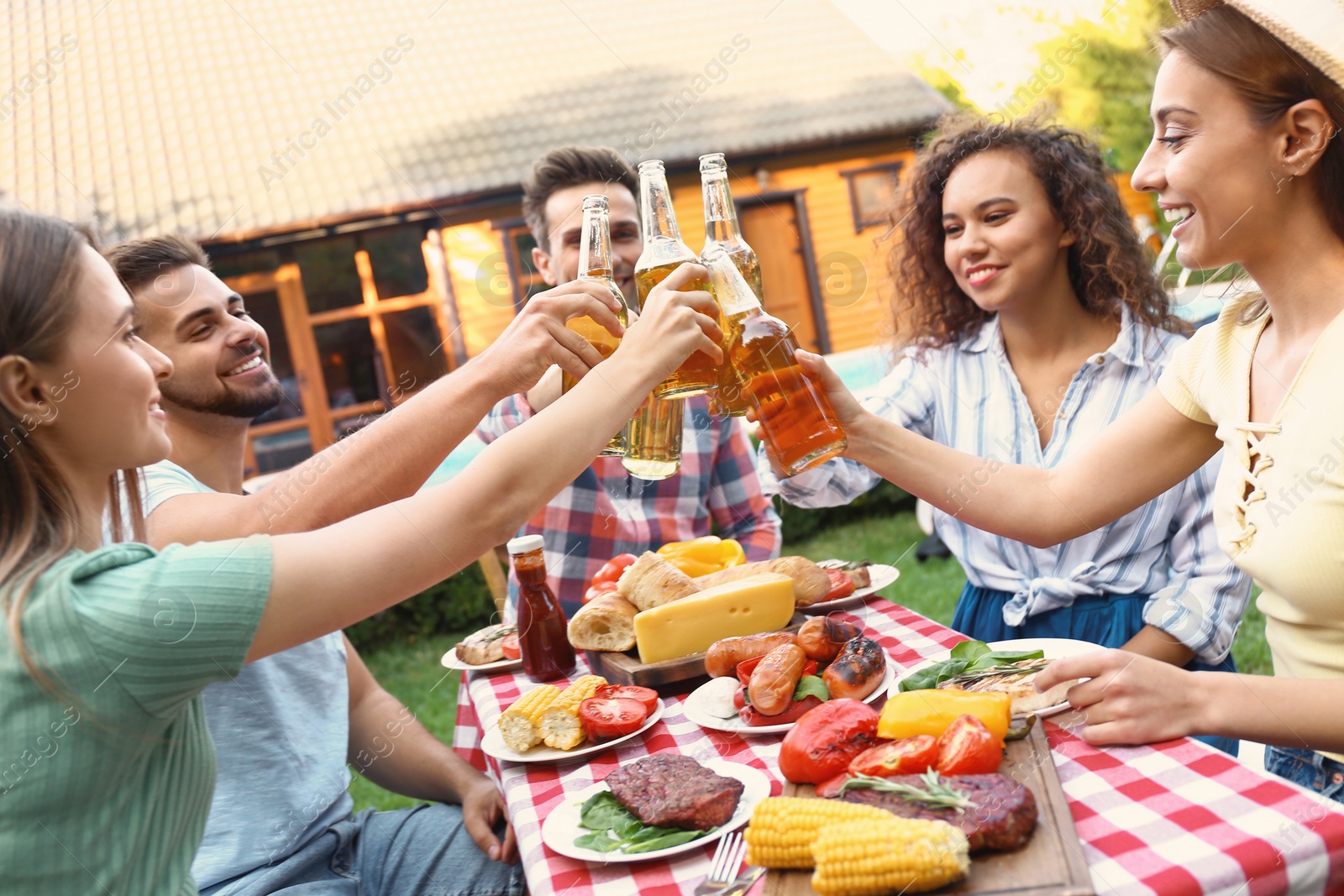 Photo of Happy friends with drinks having fun at barbecue party outdoors