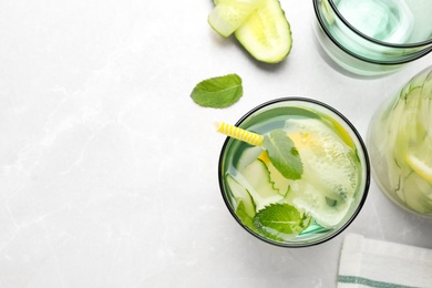 Photo of Refreshing water with cucumber, lemon and mint on white table, flat lay. Space for text