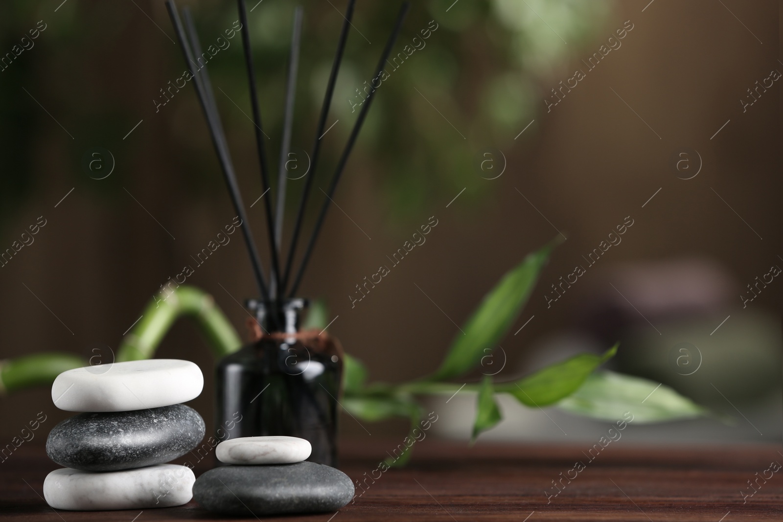 Photo of Spa stones on wooden table indoors. Space for text