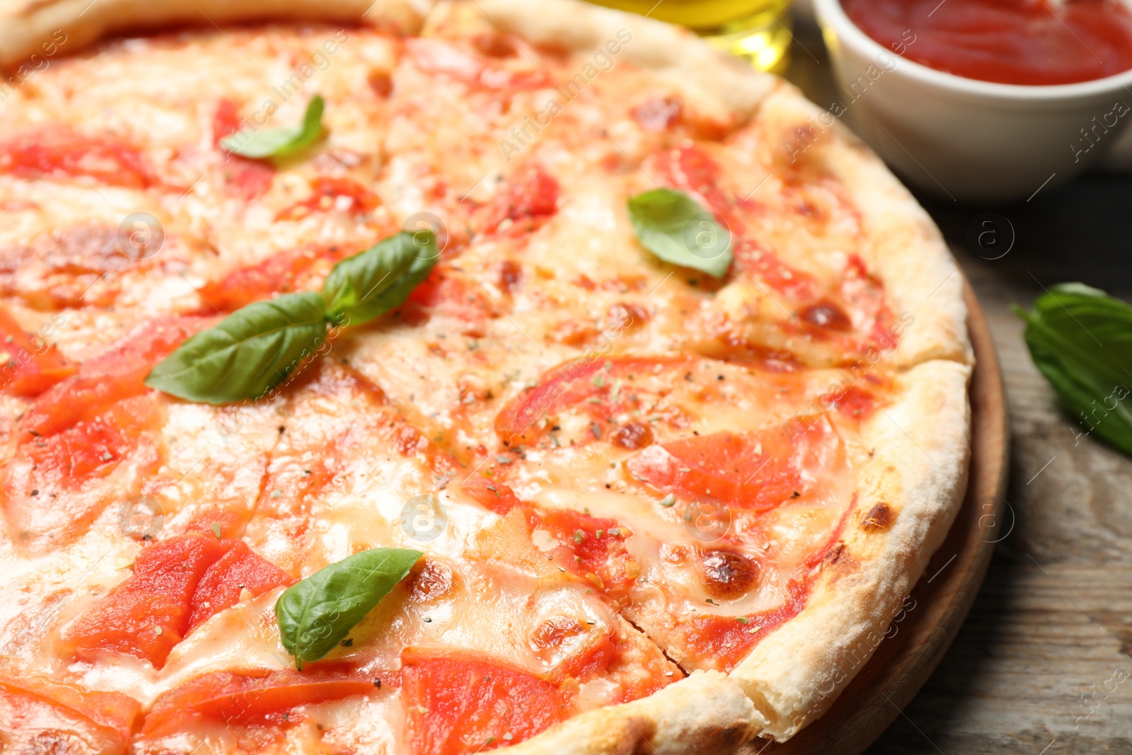 Photo of Delicious pizza Margherita on wooden table, closeup view