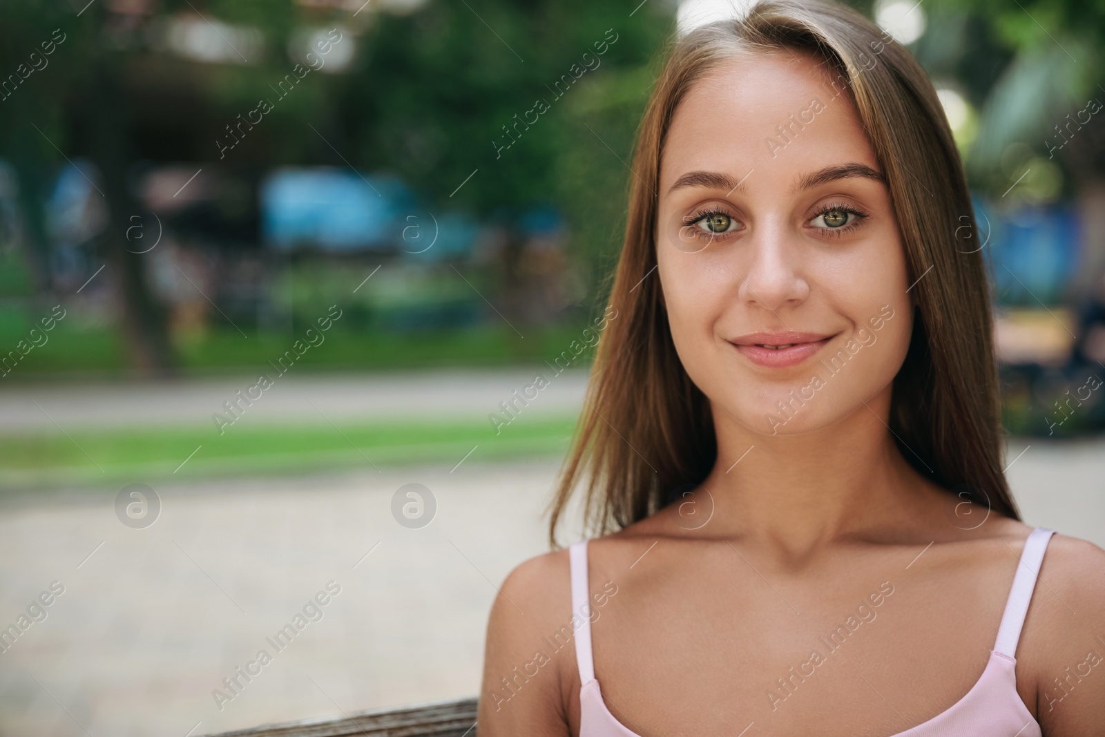 Photo of Portrait of beautiful young woman in park, space for text