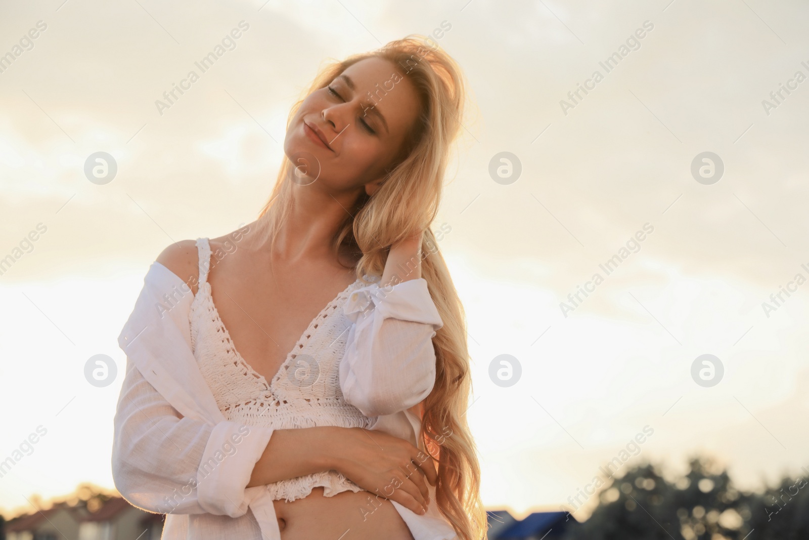 Photo of Beautiful young woman outdoors at sunset, space for text