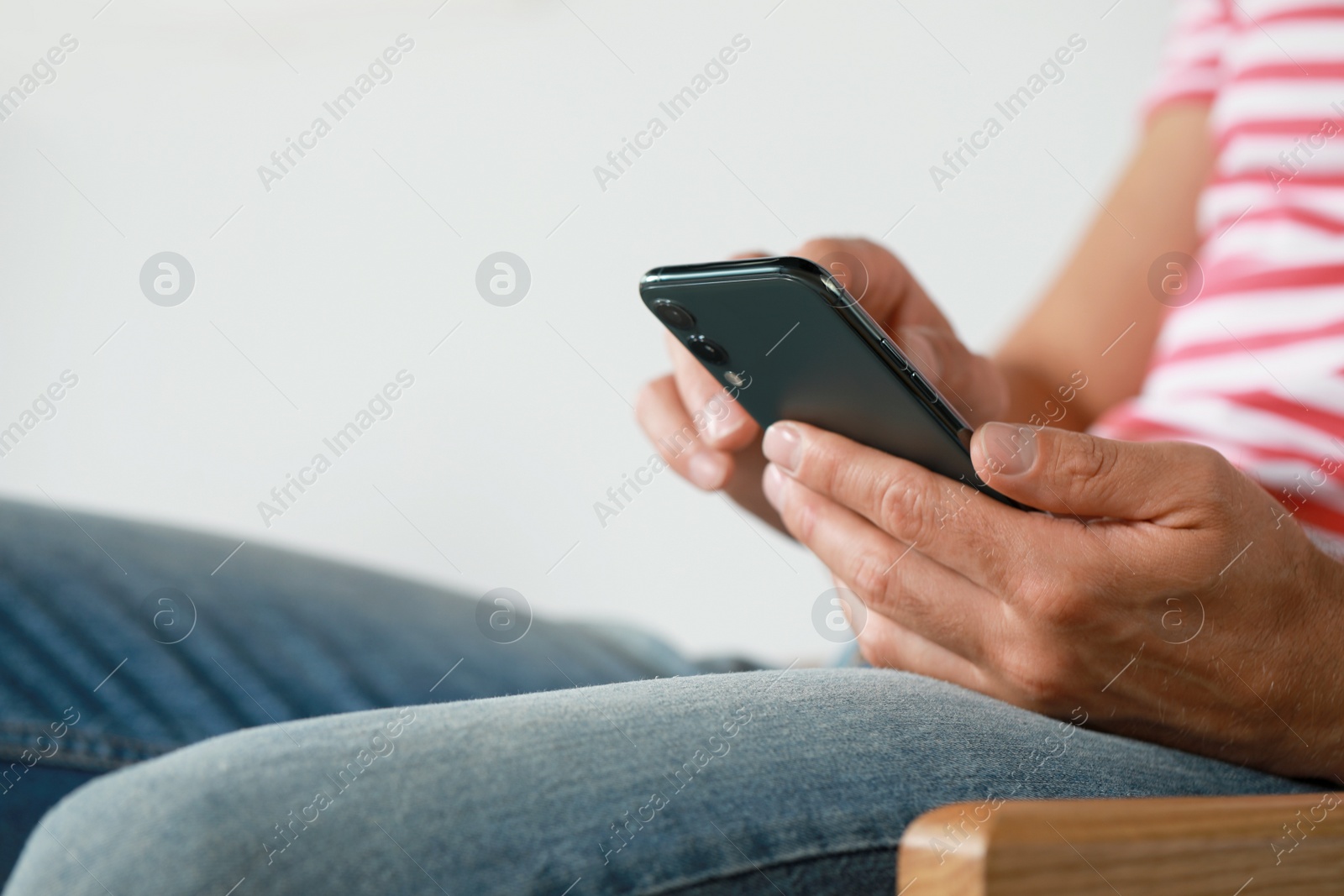 Photo of Man using smartphone at home, closeup view. Space for text