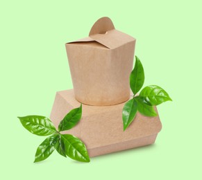 Image of Paper boxes and green leaves on color background. Eco friendly lifestyle