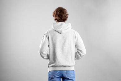 Photo of Man in hoodie sweater on light background. Space for design