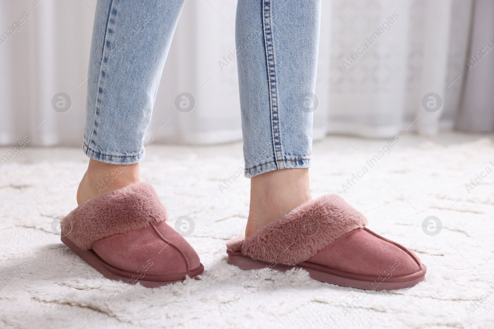 Photo of Woman in soft slippers at home, closeup