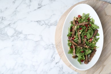 Photo of Delicious salad with beef tongue, arugula and seeds on white marble table, top view. Space for text