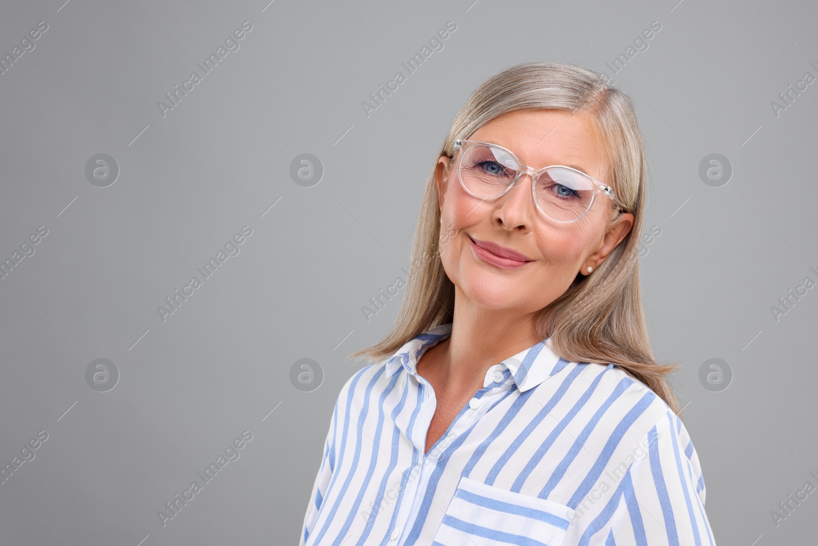 Photo of Portraitbeautiful middle aged woman in eyeglasses on light grey background, space for text