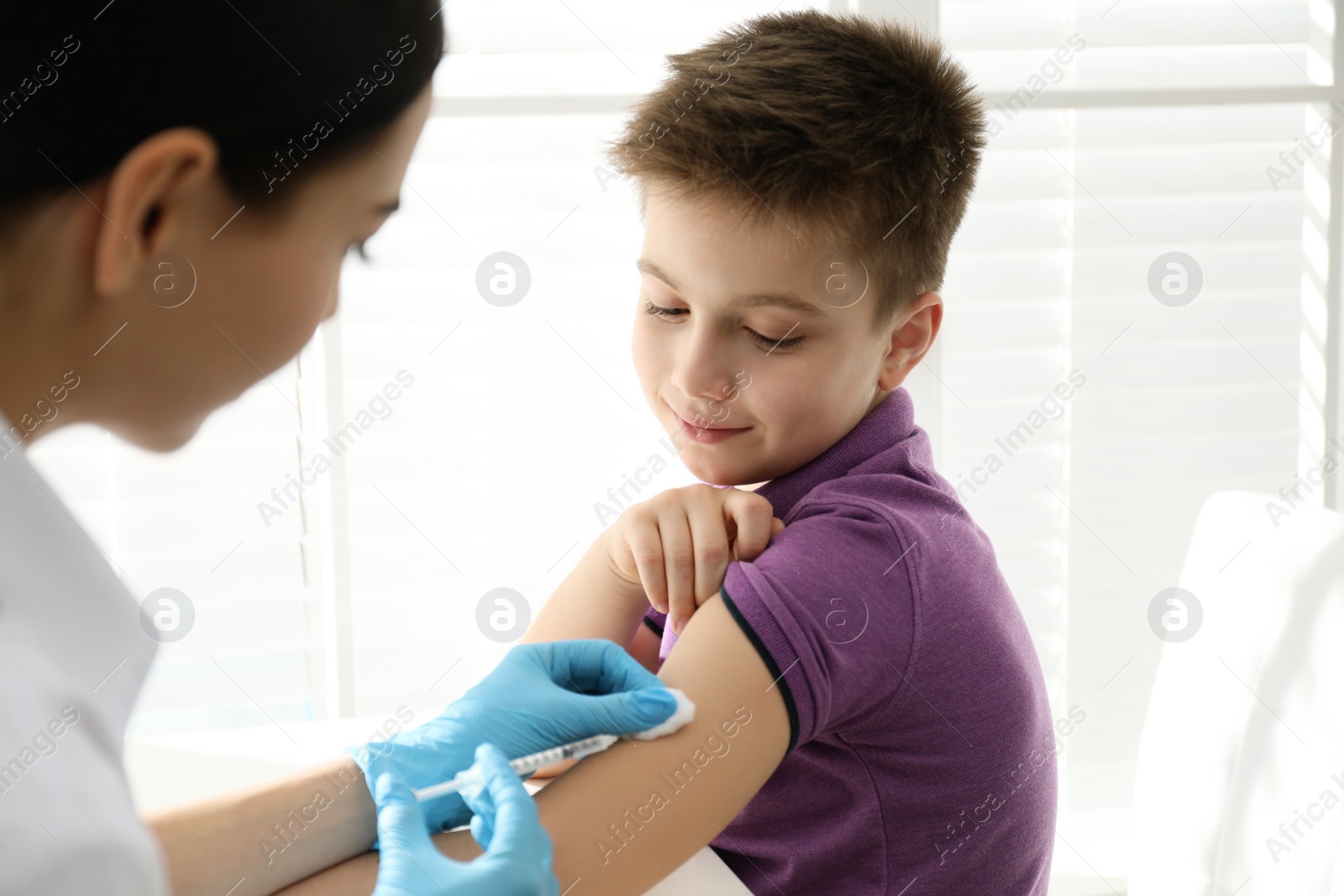 Photo of Doctor vaccinating little child in modern clinic