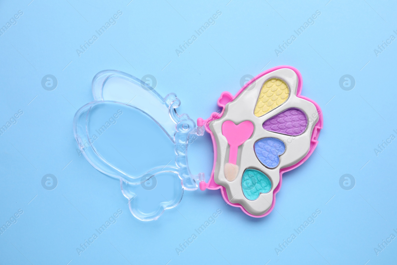 Photo of Decorative cosmetics for kids. Eye shadow palette on light blue background, top view