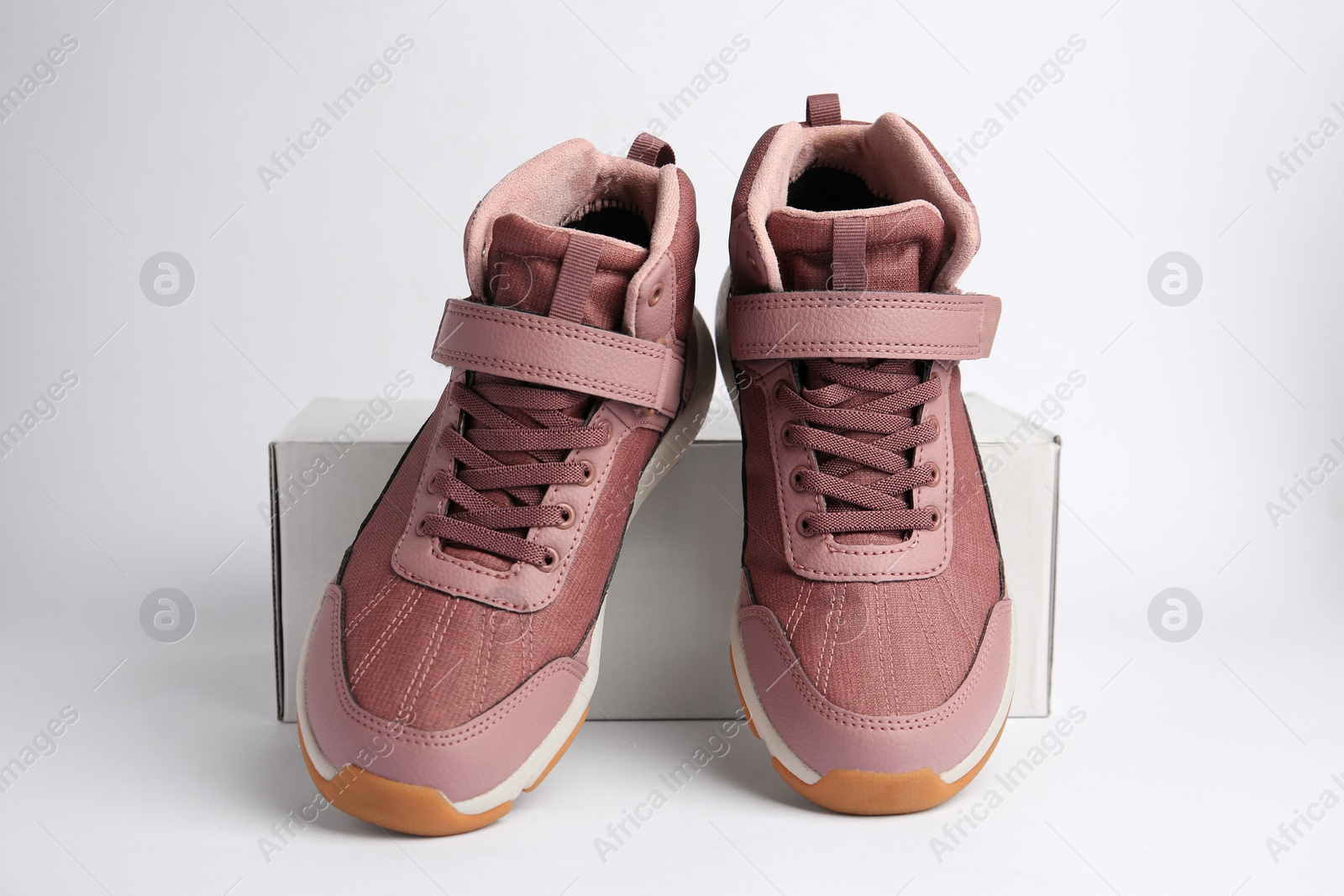 Photo of Pair of stylish kid's sneakers and box on white background